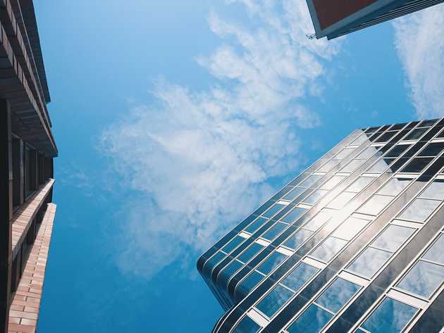 A low-angle shot of three buildings and a cloudy sky in Berlin